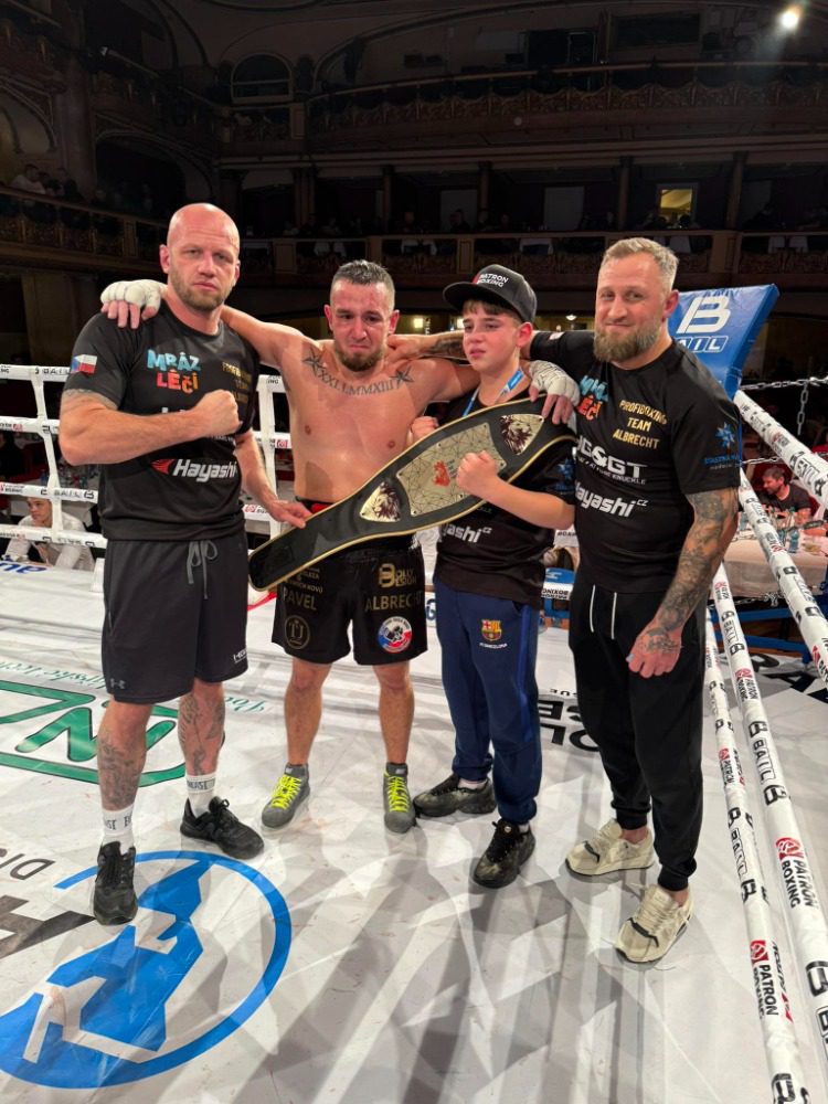 Pavel Albrecht s vítězným týmem drží šampionský pás po zápase v Lucerně 21. listopadu 2025.